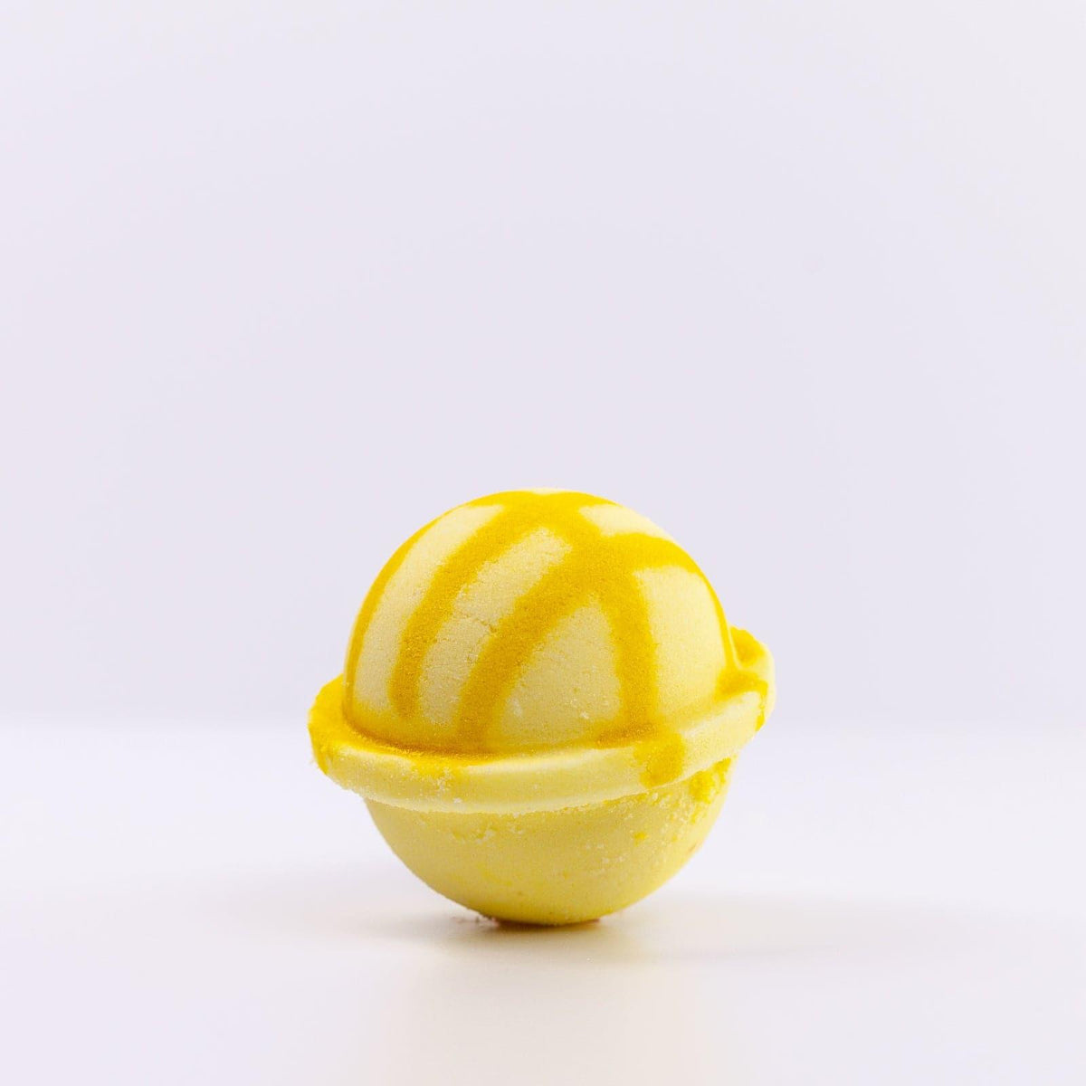 Light yellow Bath Bomb with dark yellow design against white background