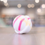 White bath bomb with light yellow and hot pink design