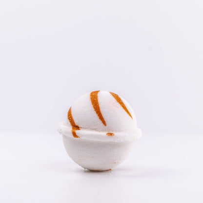 a white Narcissist Bath Bomb, with caramel design, placed upright