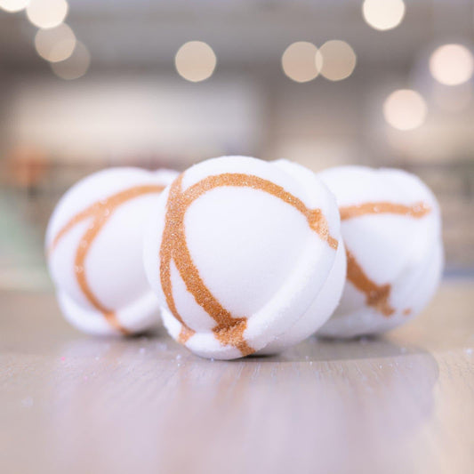 Three Narcissist Bath Bombs with bronze design on wooden counter